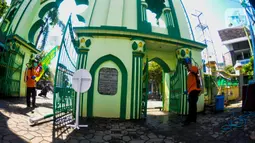 Petugas menyemprotkan cairan disinfektan di Masjid Kauman Semarang,  Jawa Tengah, Senin (16/3/2020). Penyemprotan dilakukan untuk mencegah penyebaran virus corona COVID-19. (Liputan6.com/Gholib)