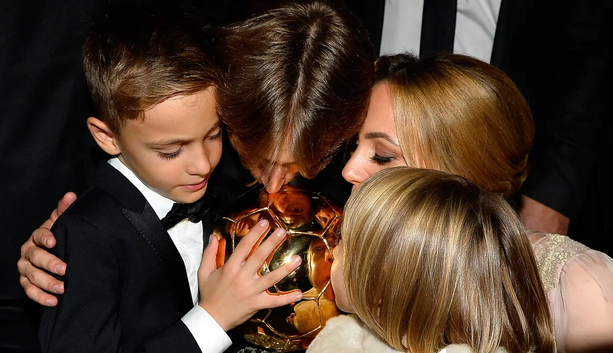 Gelandang Real Madrid, Luka Modric bersama keluarganya mencium trofi setelah memenangkan penghargaan Ballon d'Or 2018 di Paris, Senin (3/12). Penghargaan individu ini menjadi gelar Ballon d'Or pertama sepanjang karier Modric. (FRANCK FIFE/AFP)