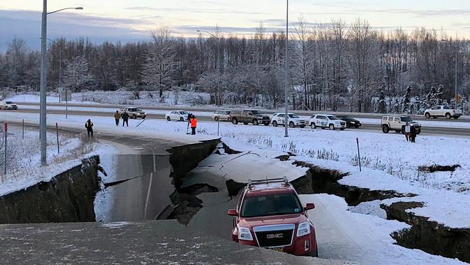 Satu mobil terperangkap di jalan Minnesota Drive yang amblas menyusul gempa bumi di Anchorage, Alaska, Jumat (30/11). Sebagian besar jalan layang di dekat bandara Anchorage runtuh, menjebak sebuah mobil di beton yang hancur. (AP Photo/Dan Joling)