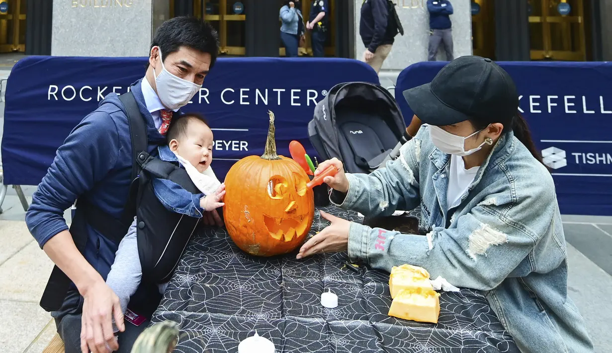 Anthony Pui dan Miho Tabaru mengukir labu dalam persiapan untuk Halloween di Rockefeller Center (22/10/2020). Kelas mengukir labu adalah bagian dari ZO Tishman Speyer. program fasilitas untuk semua orang yang bekerja di gedungnya. (Diane Bondareff/AP Images for Tishman Speyer)
