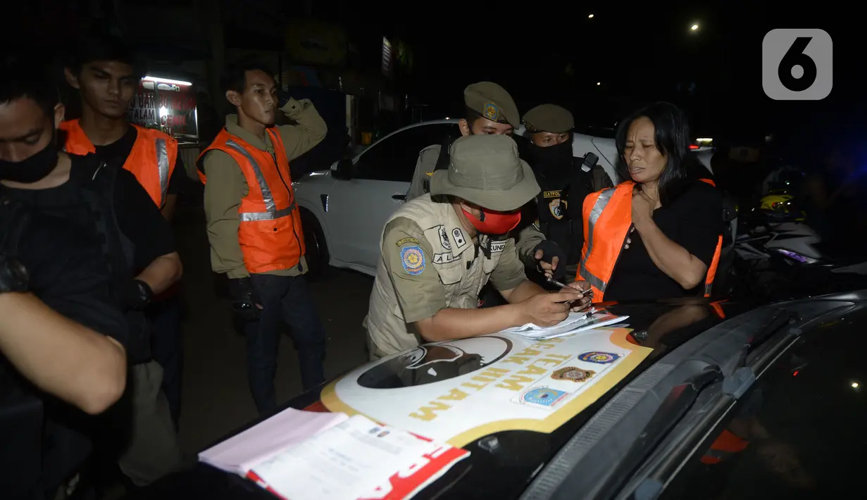 Petugas melakukan Operasi Yustisi mencegah penularan Covid-19 di Taman Perdamaian, Tangerang Selatan, Banten, Rabu (23/9/2020). Sebagai efek jera, warga yang tidak mengenakan masker diberi sanksi sosial berupa membersihkan toilet, menyapu, push up, dan denda Rp 50 ribu. (merdeka.com/Dwi Narwoko)