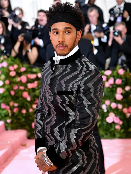 Pembalap Mercedes, Lewis Hamilton berpose saat tiba menghadiri Met Gala 2019 di Metropolitan Museum of Art di New York, AS (6/5/2019). (AFP Photo/Dimitrios Kambouris)