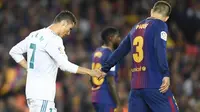 Gerard Pique (kanan, Barcelona) dan Cristiano Ronaldo (kiri, Real Madrid) menunjukkan respek pada laga di Camp Nou, Minggu (6/5/2018). (AFP/Lluis Gene)