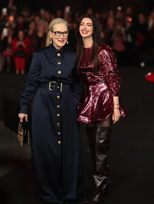 Ia tampil dengan gaya playful beradu dengan high knee boots yang statement.  [Foto: Anne Hathaway]