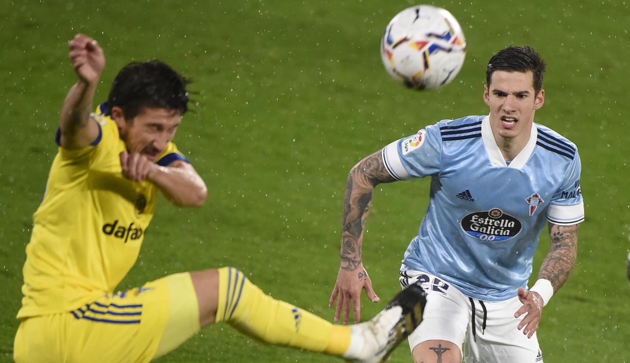 Penyerang Celta Vigo, Santi Mina, berebut bola dengan bek Cadiz, Alfonso Espino, pada laga lanjutan Liga Spanyol di Stadion Abanca Balaidos, Selasa (15/12/2020) dini hari WIB. Celta Vigo menang telak 4-0 atas Cadiz. (AFP/Miguel Riopa)