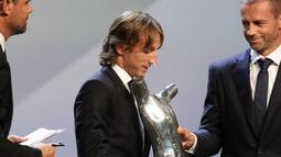 Gelandang Real Madrid asal Kroasia, Luka Modric menerima piala pemain terbaik UEFA dari presiden UEFA Aleksander Ceferin di The Grimaldi Forum di Monaco, (30/8). Modric mengalahkan Cristiano Ronaldo dan Mohamed Salah. (AFP Photo/Valery Hache)
