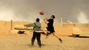 Tentara AS berusaha menangkap bola saat bermain American Football pada Thanksgiving di dalam pangkalan militer AS di Qayyara, selatan Mosul, Irak (24/141). (REUTERS/Thaier Al-Sudani)