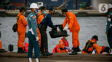 Petugas membawa body part dari kapal Basarnas di JICT II Tanjung Priok, Jakarta, Jumat (15/1/2021).  Badan SAR Nasional (Basarnas) kembali menerima paket kiriman hasil pencarian hari ketujuh. (Liputan.com/Faizal Fanani)