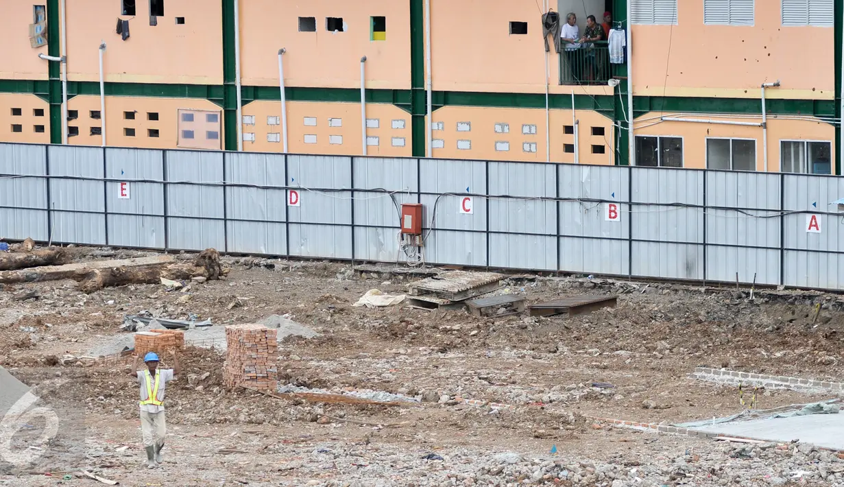 Warga melihat proyek revitalisasi Pasar Rumput, Manggarai, Jakarta, Rabu (4/1). Rencananya, Pasar Rumput akan dibangun menjadi gedung rusunanwa dengan 24-26 lantai dan 3-4 lantai pertama akan tetap difungsikan sebagai pasar. (Liputan6.com/Yoppy Renato)