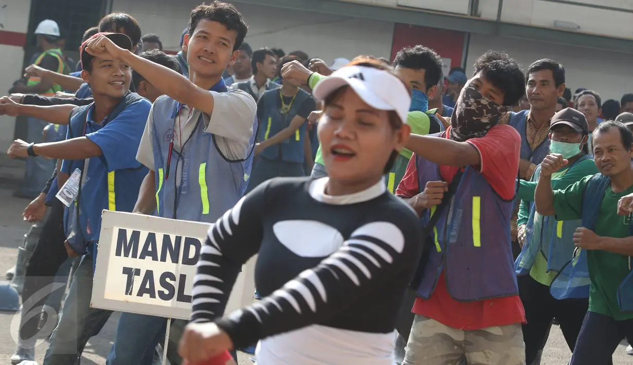 Pekerja renovasi Stadion Utama GBK mengikuti instruktur senam sebelum beraktivitas di kawasan Senayan, Jakarta, Jumat (17/3). Senam dilakukan untuk menjaga kebugaran pekerja yang rutin diadakan setiap Jumat pagi. (Liputan6.com/Immanuel Antonius)