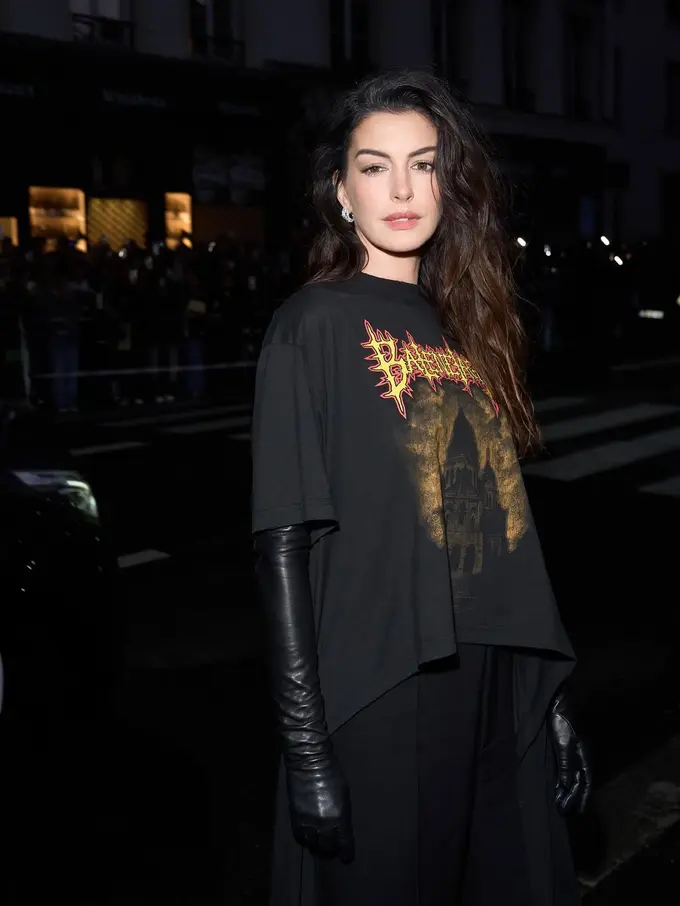 Gaya Slay Anne Hathaway dengan Kaos Oblong Hadiri Show Balenciaga di Paris Fashion Week