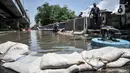 Tumpukkan karung digunakan untuk mencegah meluasnya banjir yang menggenangi Jalan RE Martadinata, Ancol, Jakarta, Selasa (9/11/2021). Banjir yang terjadi sejak 4 November 2021 masih menggenangi Jalan RE Martadinata, tepatnya di seberang Aston Mediterania. (merdeka.com/Iqbal S. Nugroho)