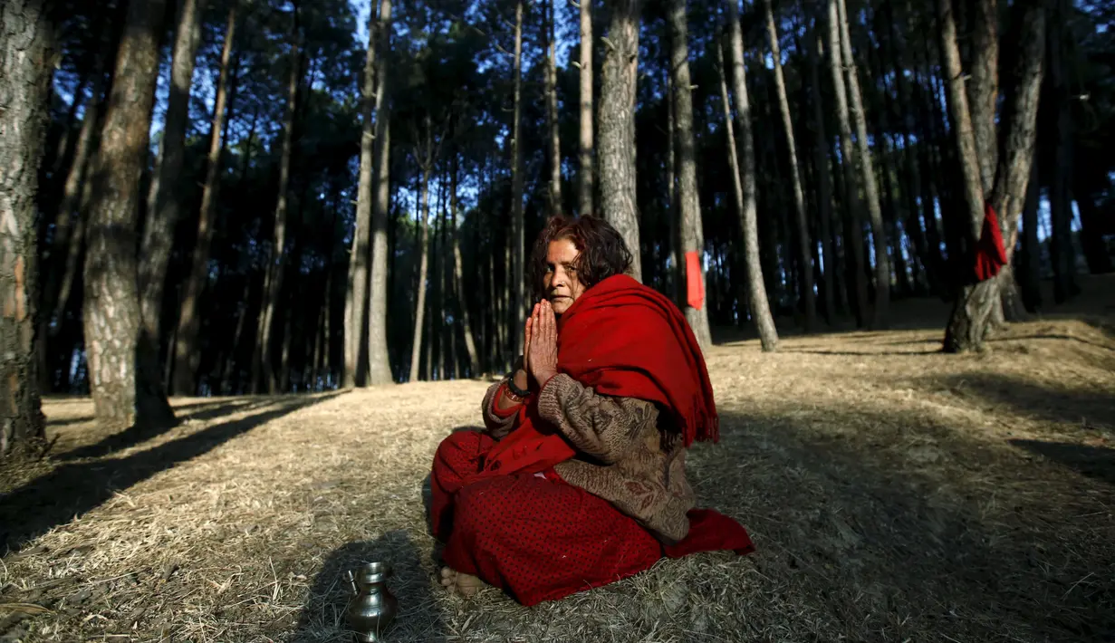 Seorang umat Hindu Nepal berdoa di hutan Changu Narayan selama festival Swasthani Bratakatha, Nepal , (19/2).Selama berlangsung festival para umat akan membacakan kitab suci Hindu Swasthani Brata Katha. (REUTERS / Navesh Chitrakar) 			