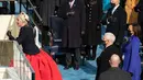 Penyanyi AS Lady Gaga menyanyikan Lagu Kebangsaan AS selama Pelantikan Presiden terpilih AS Joe Biden di Front Barat Capitol AS di Washington, DC (20/1/2021). Lady Gaga tampil mengenakan rok merah dan atasan hitam lengan panjang dengan sarung tangan kulit hitam. (Saul Loeb/Pool/AFP)