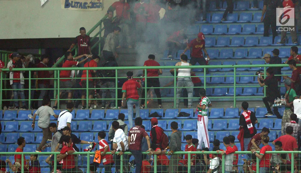 Suasana kepanikan suporter saat terjadi insiden ledakan suar pada laga persahabatan Indonesia melawan Fiji di Stadion Patriot Candrabhaga, Bekasi, Sabtu (9/2). Dikabarkan satu orang suporter tewas akibat insiden ini. (Liputan6.com/Helmi Fithriansyah)