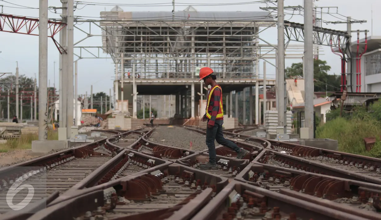 Pekerja melintasi rel di area proyek  pembangunan Stasiun Commuter Line Cikarang, Jawa Barat, Selasa (12/4). Proyek ini ditargetkan selesai dan bisa dioperasikan pada 2018. (Liputan6.com/Angga Yuniar)