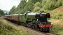 Lokomotif uap Flying Scotsman berjalan di sepanjang jalur East Lancashire Railway melalui stasiun kereta Burrs Country Park, Inggris, 5 September 2018. Kereta uap itu masih menggunakan mesin kuno berjenis A Class 60103 tahun 1923. (OLI SCARFF/AFP)