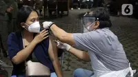 Vaksinator menyuntikan vaksin Covid-19 kepada warga di halaman Kantor Kecamatan Penjaringan, Jakarta, Kamis (19/8/2021). Vaksinasi malam ini digelar untuk menjangkau warga yang tidak bisa ikut vaksinasi pada siang hari karena bekerja dan alasan lainnya. (Liputan6.com/Helmi Fithriansyah)