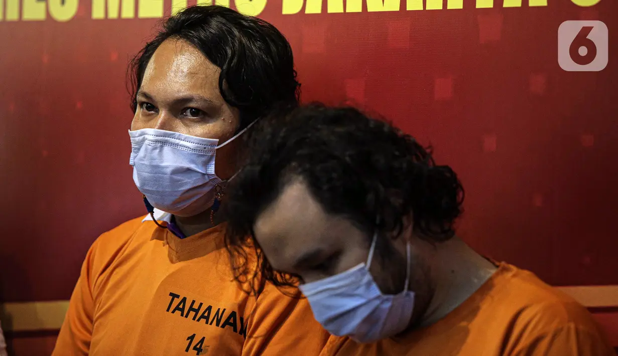 Vokalis grup band Deadsquad Daniel Mardhany (kiri) dan rekannya saat rilis kasus narkoba di Polres Jakarta Utara, Senin (3/5/2021). Kapolres Metro Jakarta Utara Kombes Pol Guruh Arif Darmawan mengatakan dalam penangkapan diamankan tembakau sintetis serta obat prohiper. (Liputan6.com/Faizal Fanani)