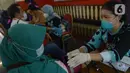 Petugas medis mengecek kesehatan warga sebelum divaksin booster di Gor Ciracas, Jakarta, Sabtu (19/3/2022). Vaksin booster diberikan kepada warga lanjut usia dan masyarakat berisiko tinggi tertular Covid-19. (merdeka.com/Imam Buhori)