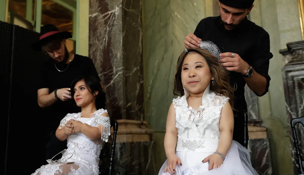 Model khusus perempuan bertubuh pendek  mempersiapkan diri sebelum pagelaran International Dwarf Fashion Show di Paris, Selasa (26/9). Ajang ini untuk meningkatkan kesadaran di dunia fesyen yang lebih inklusif dan tanpa diskriminasi. (Thomas SAMSON/AFP)