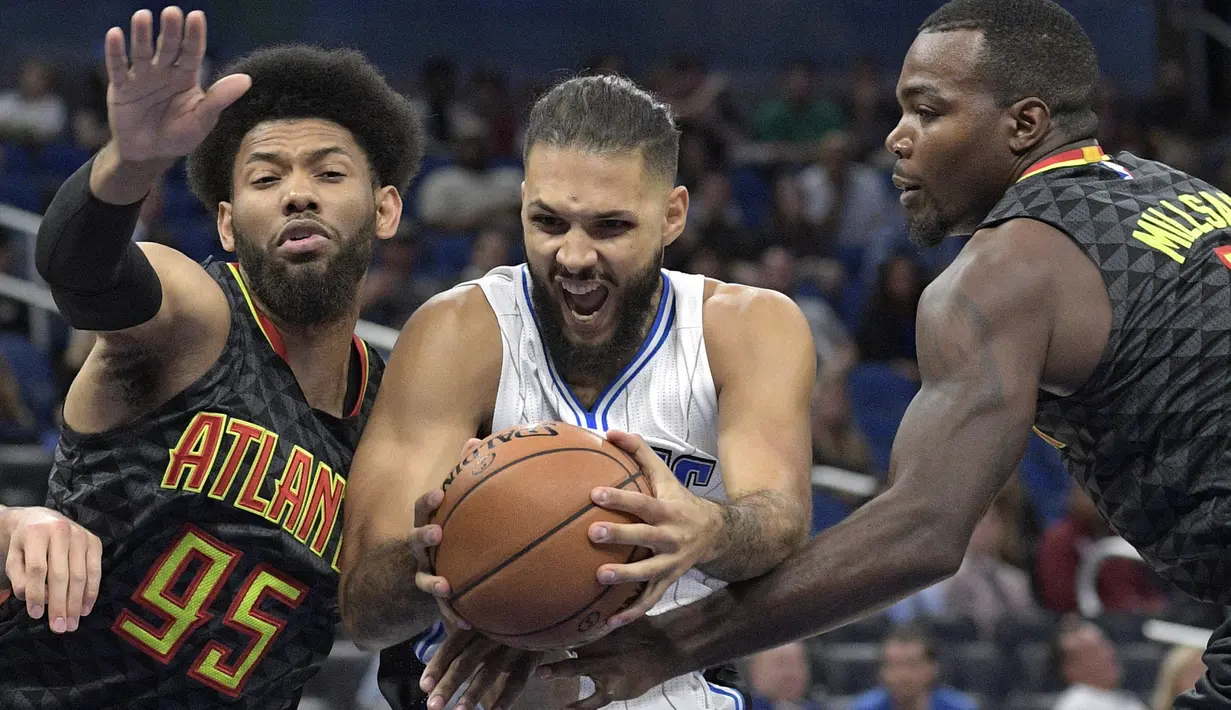 Pemain Orlando Magic, Evan Fournier  berusaha lolos dari penjagaan dua pemain Atlanta Hawks pada laga NBA preseason basketball game di Orlando, (17/10/2016) WIB. (AP/Phelan M. Ebenhack)