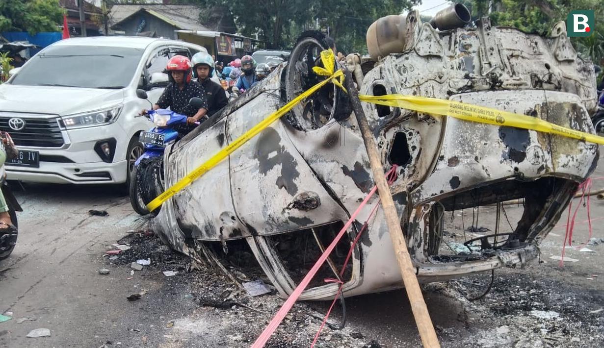 Bangkai mobil yang terbakar di luar Stadion Kanjuruhan, Malang, turut menjadi saksi bisu tragedi mengerikan yang merenggut ratusan nyawa orang. (Bola.com/Iwan Setiawan)
