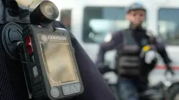 Anggota kepolisian mengenakan kamera pada dadanya saat sedang bertugas di Marseille, Prancis, 15 Februari 2017. Penggunaan kamera ini diharap dapat menurunkan keluhan masyarakat terkait adanya praktek kesewenangan-wenangan aparat. (BORIS HORVAT/AFP)