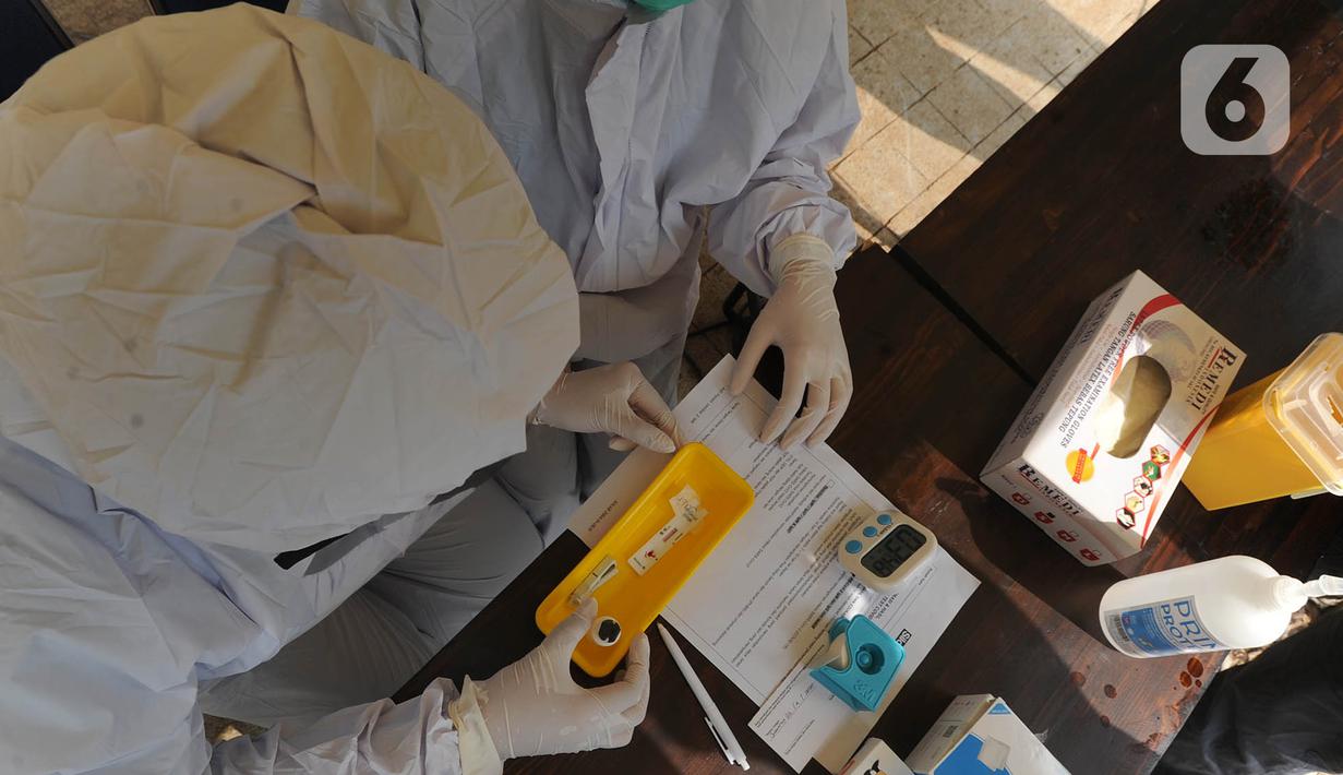 Paramedis Siloam Hospitals memeriksa sampel darah saat Rapid Test mandiri COVID -19 secara drive thru di Akses Senayan Park Jalan Gerbang Pemuda, Jakarta, Kamis (23/4/2020). Rapid Tes Covid -19 dibanderol seharga Rp 489.000, periode 17-30 April 2020 pukul 08.00-10.00 WIB. (merdeka.com/Arie Basuki)