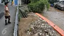 Seorang anak melintas di samping sungai Ciliwung di kawasan Manggarai, Jakarta Selatan, Rabu (8/3). Meningkatnya debit air di sungai Ciliwung dibarengi dengan sampah yang terbawa aliran sungai. (Liputan6.com/Yoppy Renato)
