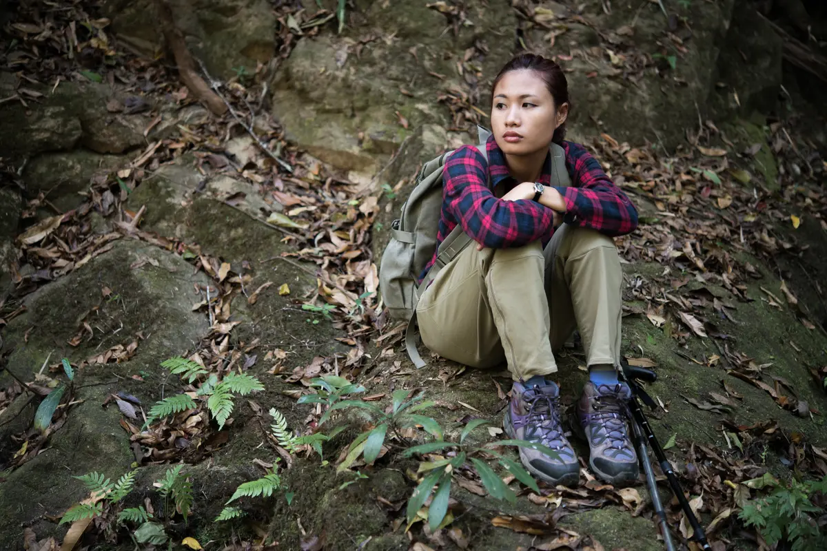 Seorang perempuan sedang duduk dan beristirahat saat mendaki gunung (Foto Dok: Freepik/jcomp)