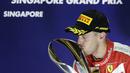 Sebastian Vettel mencium trofi juara F1 GP Singapura di Sirkuit Marina Bay, Singapura, Minggu (20/9/2015). (Reuters/Tim Chong)