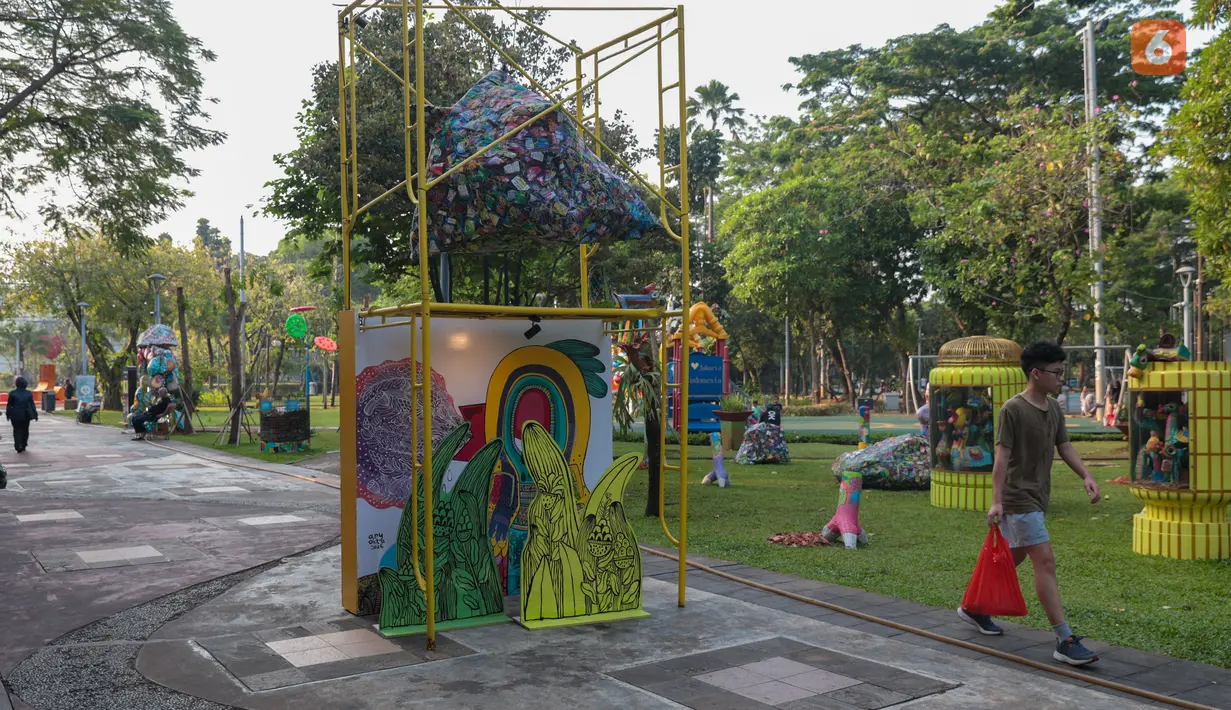 Pengunjung mengamati karya dalam pameran seni rupa kontemporer luar ruang Jakarta Provoke! di Taman Menteng, Jakarta Pusat, Jumat (17/7/2026). Pameran gratis yang berlangsung hingga 26 Juli 2026 ini menghadirkan 25 karya dari 25 seniman dan kolektif tentang dinamika kehidupan Jakarta. (KLY/Budy Santoso)