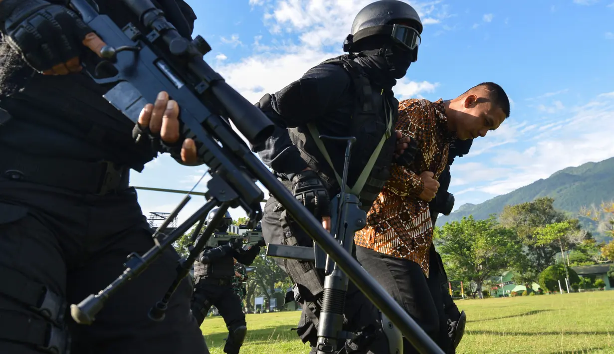Prajurit TNI Batalyon Raider 112/Dharma Jaya membawa sandera menuju helikopter pada latihan penanggulangan anti teror di Banda Aceh, Sabtu (11/5/2019). Penanggulangan anti teror merupakan bagian dari latihan pemeliharaan prajurit Raider dalam menanggulangi berbagai gangguan. (CHAIDEER MAHYUDDIN/AFP)