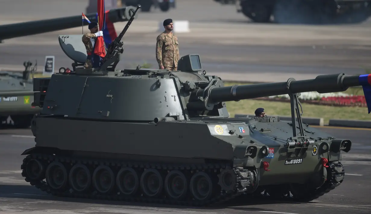 Prajurit Pakistan berdiri di atas tank saat parade Hari Militer Pakistan di Islamabad, (23/3). Parade ini memperingati Resolusi Lahore, perpisahan kaum Muslim dari Kerajaan Britania India yang jatuh pada tanggal 23 Maret 1940. (AFP Photo / Aamir Qureshi)