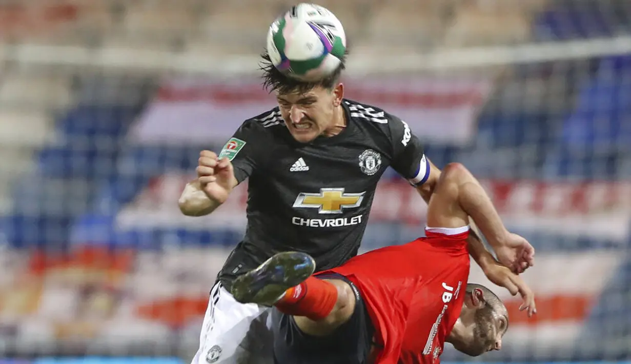 Bek Manchester United, Harry Maguire, duel udara dengan pemain Luton Town, Danny Hylton, pada Piala Liga Inggris di Stadion Kenilworth Road, Rabu (23/9/2020). Setan Merah menang dengan skor 3-0. (Nick Potts/Pool via AP)