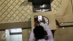Seorang jemaah berfoto di atas tempat ceramah usai salat Idul Fitri di Masjid Istiqlal, Jakarta, Rabu (6/7). Selain menjalankan salat Idul Fitri, beberapa aktivitas mereka lakukan baik seusai ataupun sebelum salat. (Liputan6.com/Faizal Fanani)