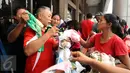 Beberapa warga berebut pakaian layak pakai di pelataran Masjid Raya Universitas Borobudur, Jakarta, Senin (20/2). Ratusan warga Cipinang Melayu terpaksa mengungsi akibat banjir yang menggenangi pemukiman mereka. (Liputan6.com/Helmi Fithriansyah)