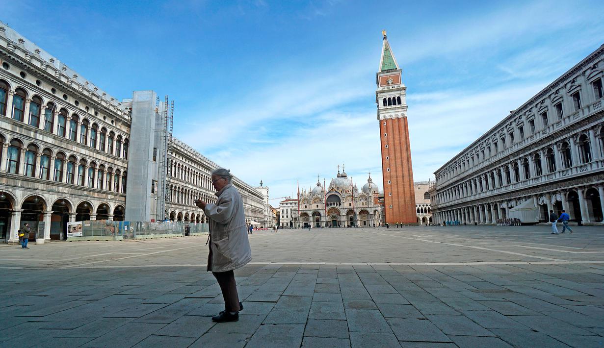 Seorang wanita berjalan di Lapangan Santo Markus, Venesia, Italia, Senin (9/3/2020). Hingga saat ini, sebanyak 9.172 pasien di Italia dinyatakan positif virus corona (COVID-19). (Anteo Marinoni/LaPresse via AP)