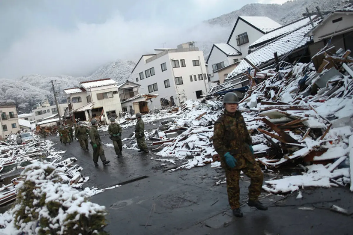 Pasukan Bela Diri Jepang berjalan di reruntuhan pasa-gempa Maret 2011 di Kamaishi