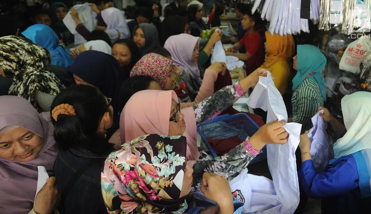 Sejumlah ibu memilih baju seragam sekolah baru untuk anaknya di salah satu kios di Jalan Pengadilan, Bogor, Rabu (11/7). Menjelang dimulainya tahun ajaran baru, para orang tua disibukan belanja kelengkapan sekolah anak mereka. (Merdeka.com/Arie Basuki)