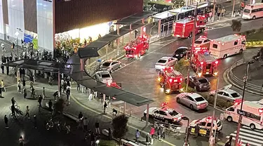 Petugas pemadam kebakaran dan petugas penyelamat berkumpul setelah seorang pria mencoba melakukan pembunuhan terhadap penumpang di luar Stasiun Kokuryo di Jalur Keio di kota Chofu di Tokyo (31/10/2021). Setidaknya 10 orang terluka dalam serangan tersebut. (AFP/Jiji Press/STR)