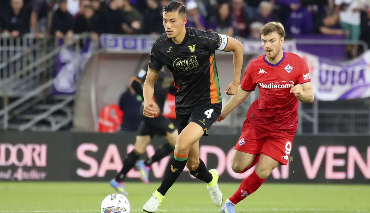Pemain Venezia, Jay Idzes (kiri) menggiring bola melewati pemain Fiorentina dalam laga lanjutan Liga Italia 2024/2025 di Stadio Pier Luigi Penzo, Venezia, Italia, Senin (12/05/2025) waktu setempat. (AP Photo/LaPresse/Paola Garbuio)