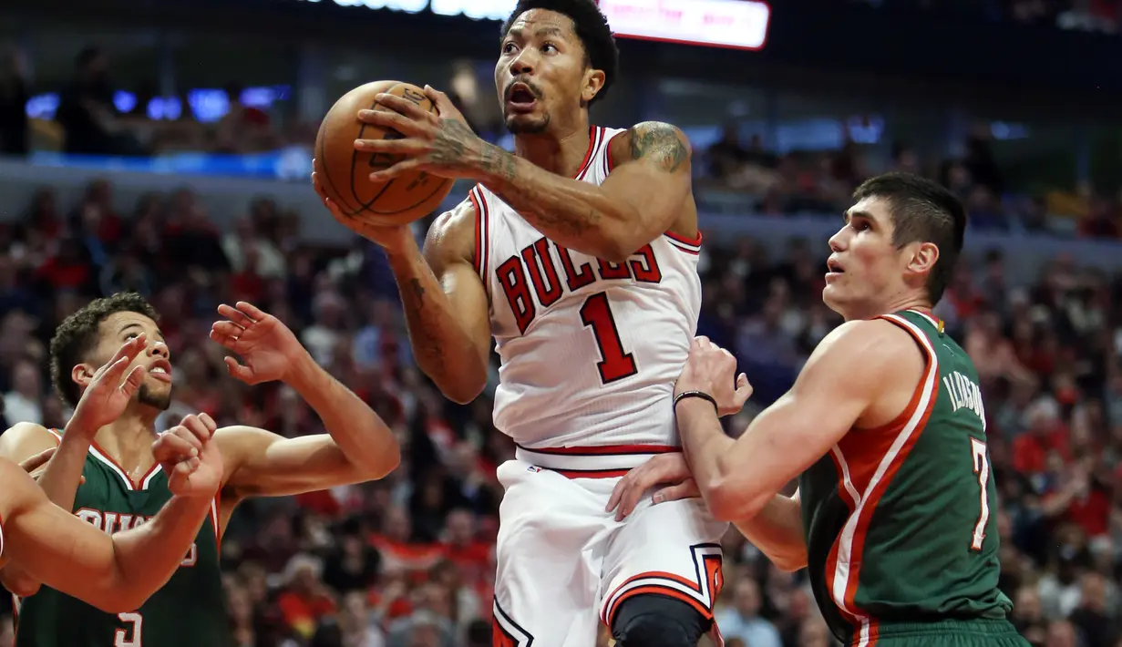 Derrick Rose melakukan jump shot diantara pengawalan ketat pemain Bucks (Jerry Lai-USA TODAY Sports)