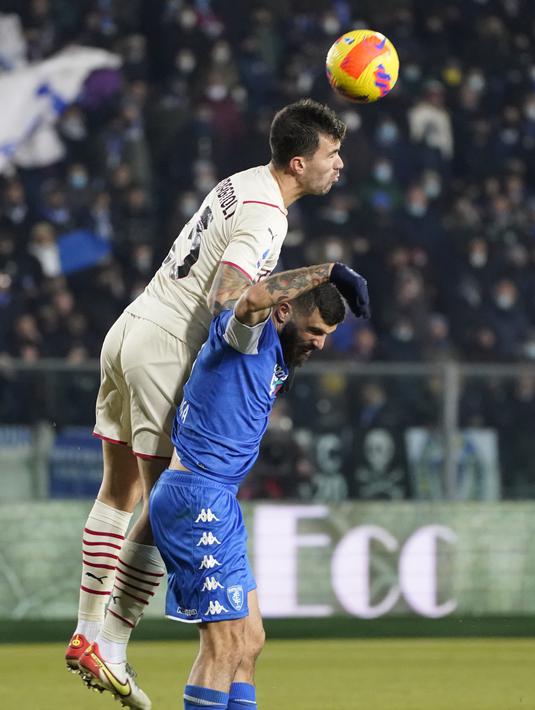 Penyerang Empoli, Patrick Cutrone berebut bola dengan bek AC Milan, Alessio Romagnoli pada pertandingan Liga Serie A Italia di Stadion Carlo Castellani di Empoli, Italia, Kamis (23/12/2021). Kemenangan ini membuat AC Milan berada di posisi kedua klasemen dengan 42 poin. (Marco Bucco/LaPresse via AP)