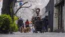 Orang-orang berjalan di trotoar bawah kanopi bunga sakura di Tokyo, Jepang, Minggu (27/3/2022). (AP Photo/Kiichiro Sato)