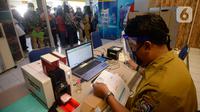 Petugas melayani warga yang akan melakukan pencetakan di mesin Anjungan Dukcapil Mandiri (ADM) di Pamulang Square, Tangerang Selatan, Senin (15/9/2020). Pemkot Tangsel memudahkan pelayanan kependudukan untuk membuat KTP El, Kartu Identitas Anak dan Kartu Keluarga. (merdeka.com/Dwi Narwoko)