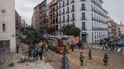 Petugas pemadam kebakaran dan polisi bekerja di lokasi ledakan di pusat kota Madrid, Spanyol, Rabu (20/1/2021). Ledakan keras telah menghancurkan sebagian bangunan kecil yang diapit oleh sekolah dan panti jompo di pusat ibu kota Spanyol. (AP Photo/Manu Fernandez)