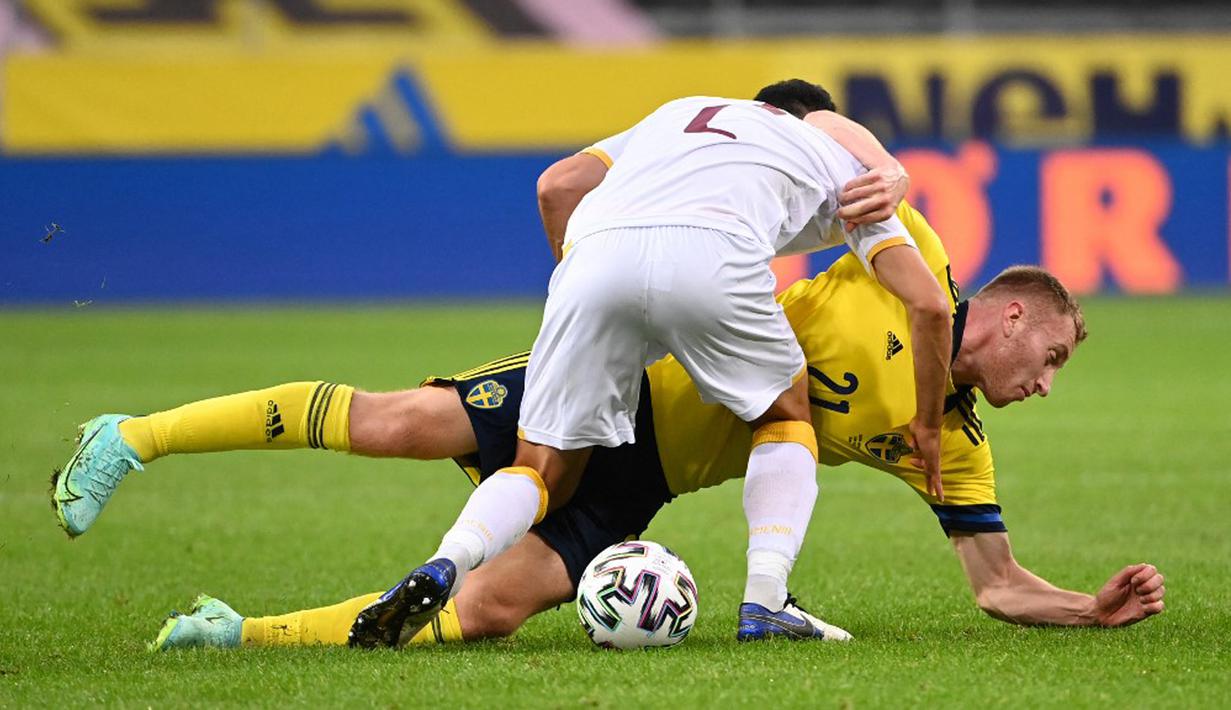 Pemain Armenia Andre Calisir (depan) berebut bola dengan pemain Swedia Dejan Kulusevski pada pertandingan persahabatan jelang Euro 2020 di Solna, Swedia, Sabtu (5/6/2021). Swedia menang 3-1. (Jonathan NACKSTRAND/AFP)