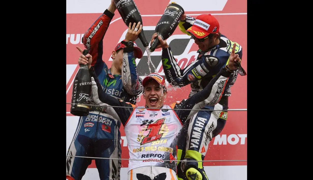 Pembalap Yamaha MotoGP, Jorge Lorenzo (kiri) dan Valentino Rossi mengguyurkan sampanye ke Marc Marquez di podium kemenangan di Sirkuit Motegi, Jepang, (12/10/2014). (AFP PHOTO/Toshifumi Kitamura)